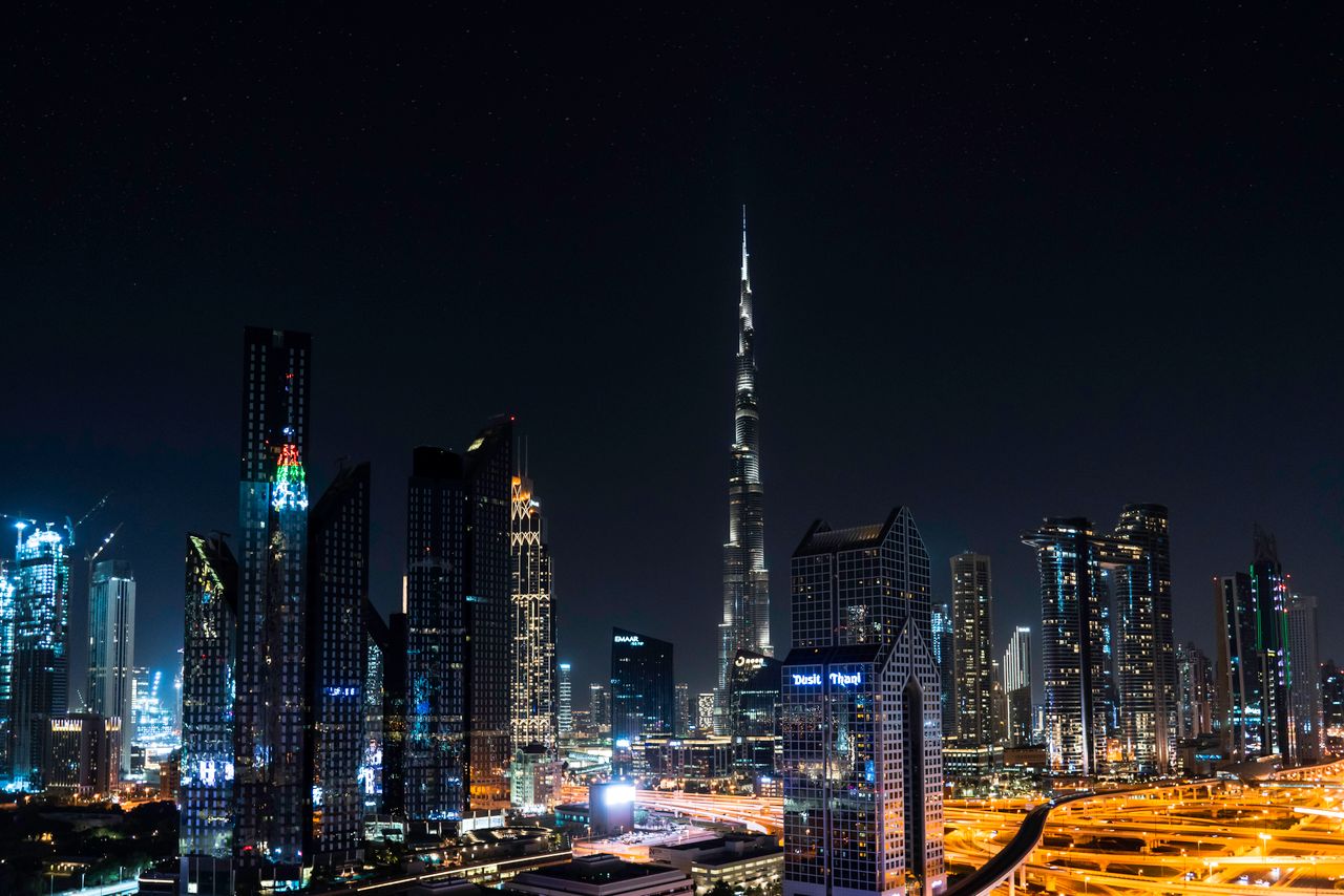 Stunning nighttime view of Dubai's skyline with the iconic Burj Khalifa illuminated under a starry sky.